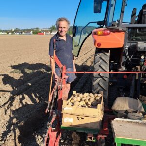 Bauer Hans neben seinem Traktor mit Erdäpfelsetzgerät